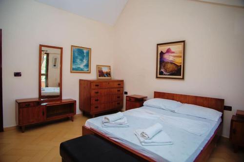 ein Schlafzimmer mit einem Bett, einer Kommode und einem Spiegel in der Unterkunft Apartament near the center of city 2 in Vlorë