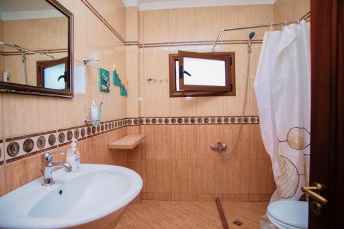 ein Badezimmer mit Waschbecken, Toilette und Spiegel in der Unterkunft Apartament near the center of city 2 in Vlorë