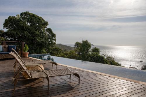 a deck with two chairs and a view of the ocean at Casa Mirador Boutique Hotel in Búzios