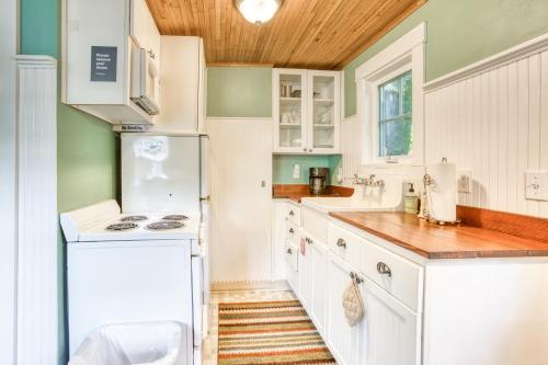 a kitchen with white appliances and a wooden ceiling at Hidden Villa Cottages #1, #2, and #3 in Cannon Beach