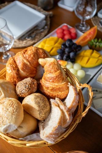 a basket of pastries and fruit on a table at Casa Mirador Boutique Hotel in Búzios