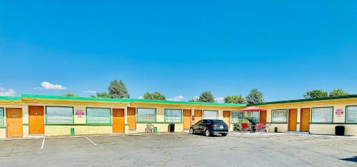 a car parked in a parking lot in front of a building at Sage N Sand Motel in Moses Lake