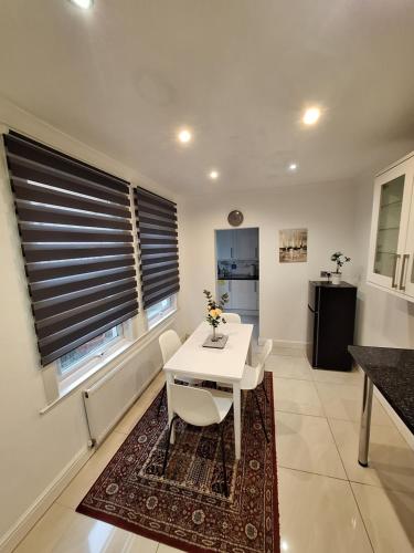 ein Wohnzimmer mit einem weißen Tisch und Stühlen in der Unterkunft B&T Pleasure Homes - Southend in Southend-on-Sea