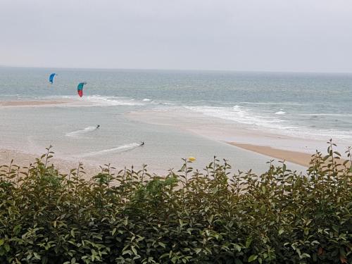 two people are flying kites on the beach at LE CHALET in Saint-Pierre-dʼArthéglise