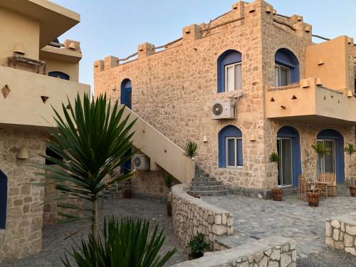 a stone building with a palm tree in front of it at Light House in Marsa Alam City