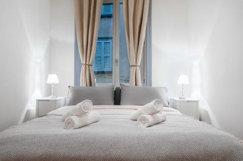 a white bed with two pillows on it with a window at FUNICOLARE 23 - Hystoric Apartment Immerso nel Cuore di Città Alta in Bergamo