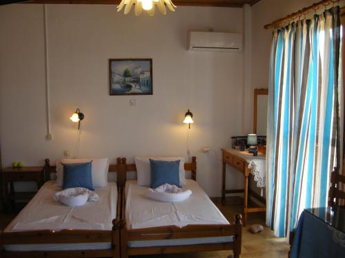 a bedroom with a bed with blue pillows at Alkioni Studios in Karlovasi
