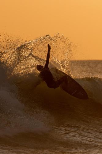 a man riding a wave on a surfboard in the ocean at Hotel Santa Teresa by the Beach in Santa Teresa Beach