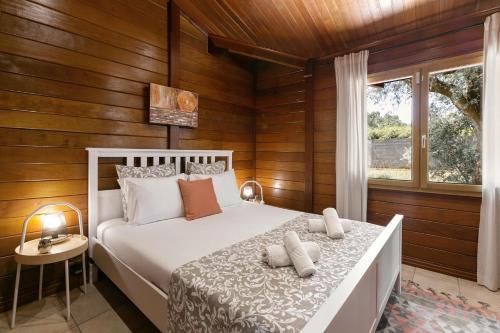 Schlafzimmer mit einem weißen Bett und Holzwänden in der Unterkunft Casa da Poesia in Pedreiras
