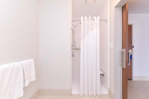 y baño blanco con ducha y toallas blancas. en Holiday Inn Express Glenwood Springs Aspen Area, an IHG Hotel, en Glenwood Springs
