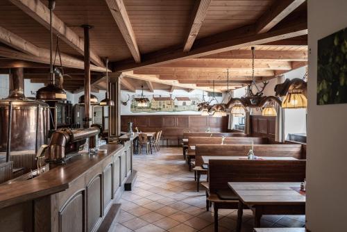 un restaurante con mesas y bancos de madera y techos de madera en Hotel Stanglbräu 