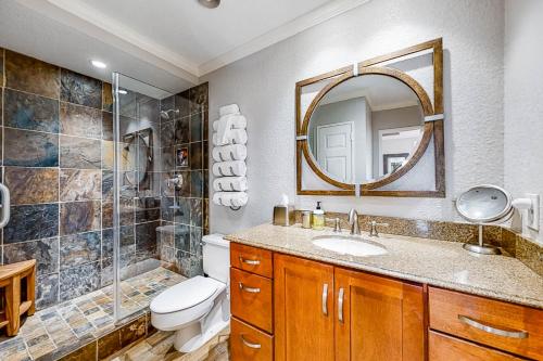 a bathroom with a sink and a toilet and a mirror at San Luis Ocean Oasis in Galveston