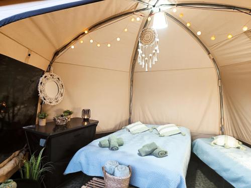 a bed in a tent with towels on it at Glamping Rožnov in Rožnov pod Radhoštěm