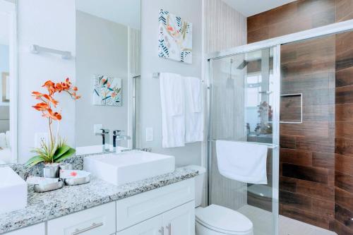 a white bathroom with a sink and a shower at Gorgeous 4 Suites DREAM Villa 5 min to Disney in Orlando