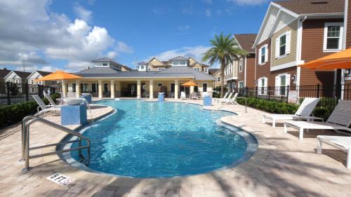 a swimming pool with chairs and a house at Gorgeous 4 Suites DREAM Villa 5 min to Disney in Orlando