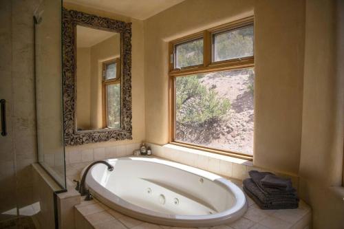 a large bath tub in a bathroom with a window at Sun and Ski! Beautiful, Downtown, on 1.5 Acres! in Santa Fe