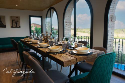 una mesa larga en una habitación con sillas y ventanas en Cal Ganyada, Casa Rural Cardona en Cardona
