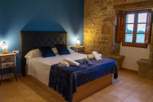 een slaapkamer met een groot bed met blauwe muren bij Cal Ganyada, Casa Rural Cardona in Cardona