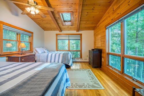 two beds in a room with windows at Lakeside Cottages on Toddy Pond in Orland