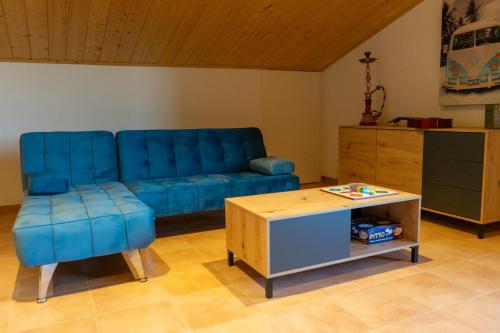 a living room with a blue couch and a table at Cal Ganyada, Casa Rural Cardona in Cardona