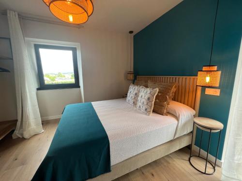 a bedroom with a bed with a blue wall at Casal de pelaio in Barreiros