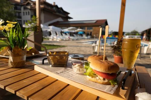 サパレヴァ・バニャにあるThermal Hotel Seven Seasonsの木製テーブルの上でサンドイッチとドリンク
