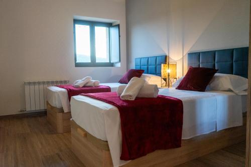 a bedroom with two beds with red and white sheets at Cal Ganyada, Casa Rural Cardona in Cardona
