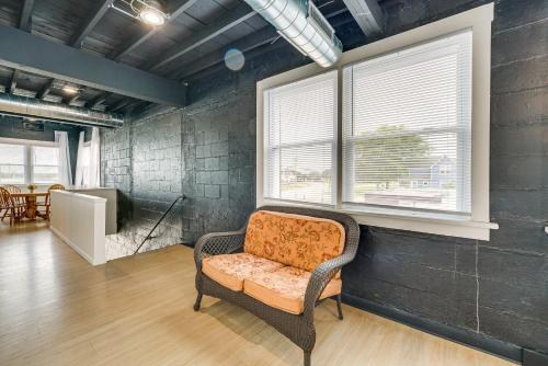 een woonkamer met een stoel en een raam bij Modernized St Clair Apartment Walk to Boardwalk! 