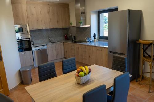 a kitchen with a table with a bowl of fruit on it at Cal Ganyada, Casa Rural Cardona in Cardona