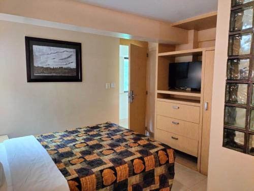 a bedroom with a bed and a flat screen tv at Hotel y Aguas Termales de Chignahuapan in Chignahuapan