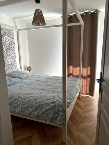 une chambre avec un lit superposé à baldaquin dans l'établissement Appartement cosy avec balcon et piscine, à Besançon