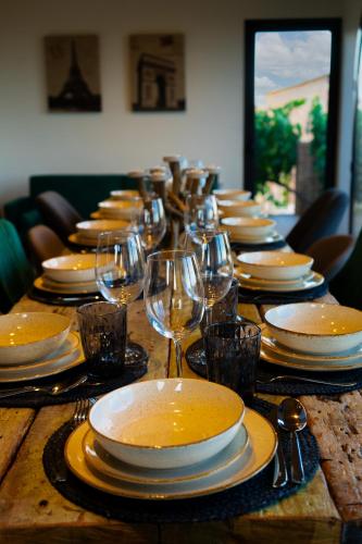 a long wooden table with plates and wine glasses at Cal Ganyada, Casa Rural Cardona in Cardona