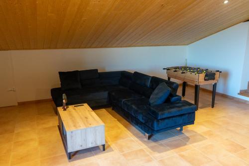 a living room with a black couch and a table at Cal Ganyada, Casa Rural Cardona in Cardona