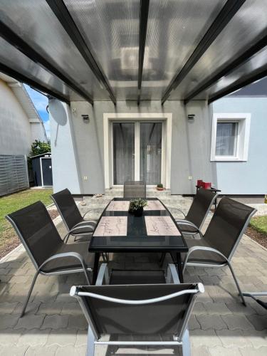 a patio with a table and chairs on a patio at Laura Luxury Apartman Gyenesdiás in Gyenesdiás