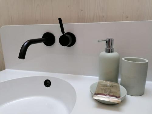 a white sink with a bottle of soap and a candle at Tiny House 1 im schönen Allgäu mit großem Garten, Naturnah in Bad Wurzach