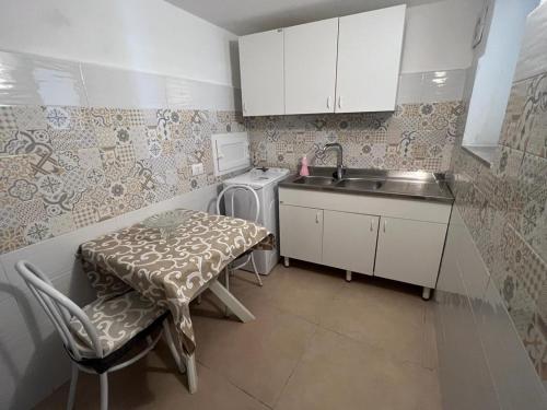 a small kitchen with a table and a sink at Albemarooms in Noto