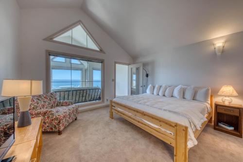 1 dormitorio con cama, sofá y ventana en Beach Loop Condos, en Bandon