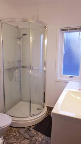 ein Bad mit einer Dusche, einem WC und einem Waschbecken in der Unterkunft Koselig leilighet med balkong og parkering. in Stavanger