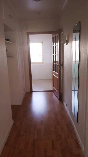 an empty hallway with a door and a window at Koselig leilighet med balkong og parkering. in Stavanger