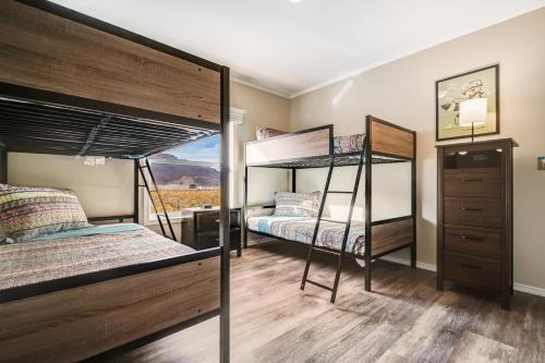 a bedroom with two bunk beds and a dresser at Spanish Valley Vineyard - Both homes in Moab