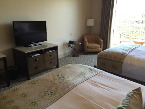 a hotel room with a bed and a flat screen tv at Ponte Vineyard Inn in Temecula