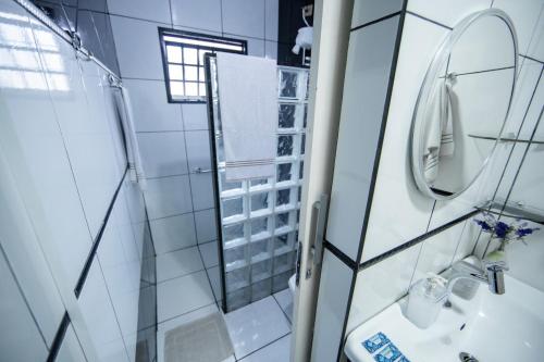 a bathroom with a shower and a sink and a mirror at Cachoeira dos pássaros in Foz do Iguaçu