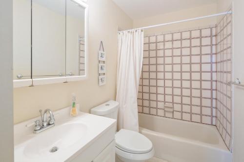 a white bathroom with a toilet and a sink at Lobster Lodge and Manatee Manor in Duck Key