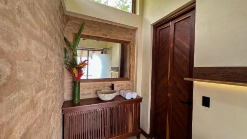 a bathroom with a mirror and a vase on a shelf at Villa Canopy Minca in Minca