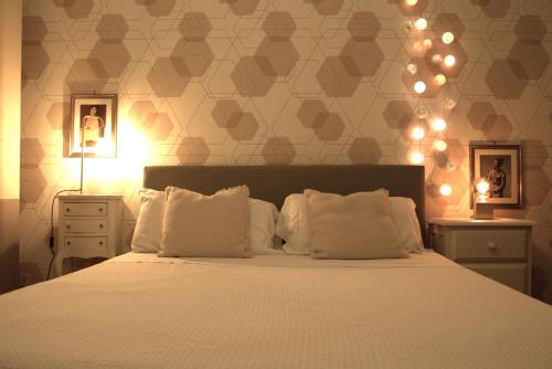 a bedroom with a bed with white pillows and lights at Appartamento Sofia - CISE 18741 in Rome