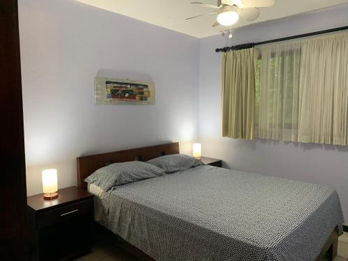 um quarto com uma cama e 2 candeeiros nas mesas em Cocomarindo Condo #72 em Coco