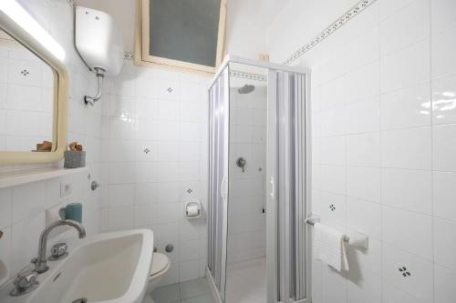 a white bathroom with a shower and a sink at Villa Diana - Beach & Rooms in Ischia
