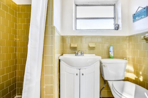 a bathroom with a sink and a toilet and a window at Fisherman's Retreat in Conch Key