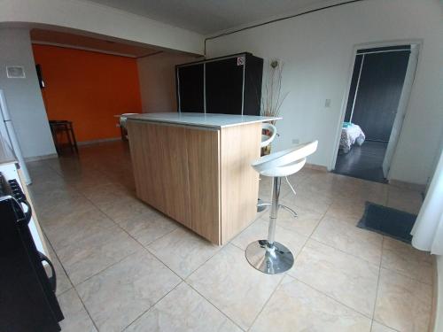 a kitchen with a counter and a stool in a room at Apartamento entero - Ushuaia, Tierra del Fuego in Ushuaia