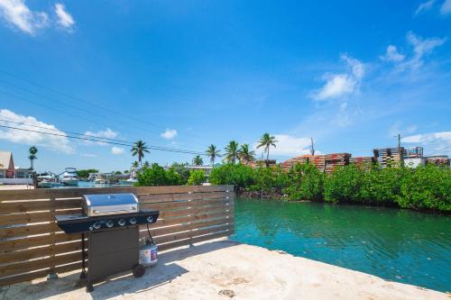 a barbecue grill sitting on a wall next to a river at Fisherman's Retreat in Conch Key